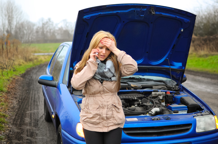 Junge Frau hat eine Autopanne und ruft den Abschleppdienst