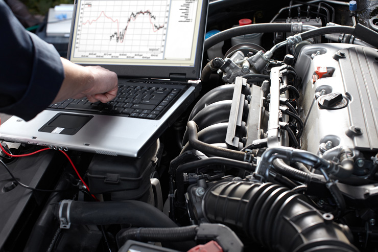 Motorencheck mit Laptop in einer Werkstatt